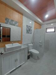 Modern bathroom with white marble walls and wooden ceiling finish