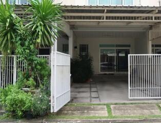 photo of the house front entrance with gate and plants