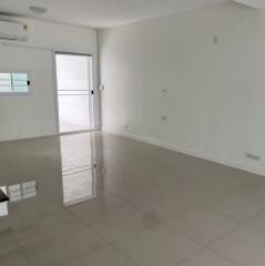 Spacious empty living room with tile flooring and access to balcony