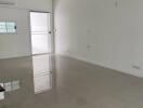 Spacious empty living room with tile flooring and access to balcony