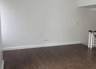 Spacious empty living room with wooden flooring and white walls