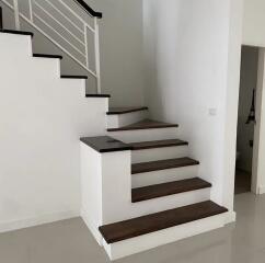 Modern staircase with dark wooden steps and white railings