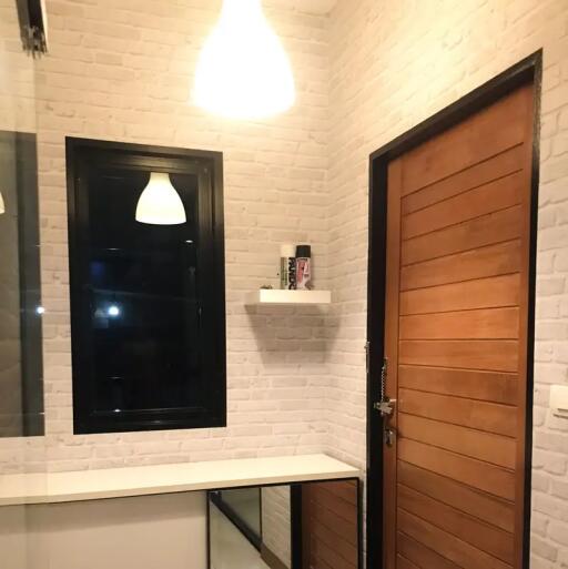 Modern bathroom with wooden door and white brick walls