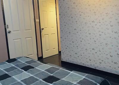 Bedroom with patterned wallpaper and bedspread