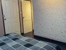 Bedroom with patterned wallpaper and bedspread