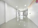 Spacious and modern living area with bright white walls and large reflective floor tiles