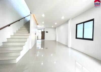Bright, spacious living area with tiled flooring and staircase