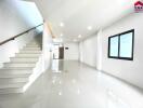 Bright, spacious living area with tiled flooring and staircase