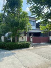 Exterior view of a two-story house with surrounding trees