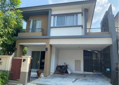 Modern two-storey house with a gated driveway and balcony