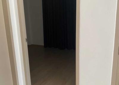Entrance to a room with wooden flooring and dark curtains