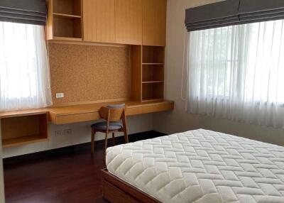 Spacious bedroom with built-in wooden desk and shelves