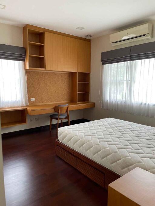 Spacious bedroom with built-in wooden desk and shelves