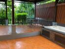 Spacious outdoor patio with tiled flooring and a covered sitting area.