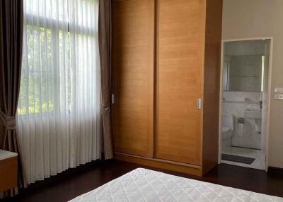 Bedroom with large window, wooden wardrobe, and ensuite bathroom