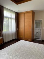 Bedroom with large window, wooden wardrobe, and ensuite bathroom