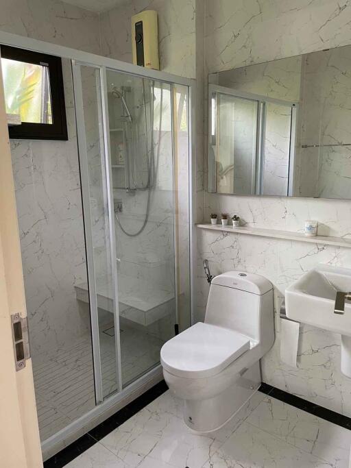 Modern bathroom with glass-enclosed shower, toilet, and sink