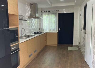 Modern kitchen with wooden flooring and white cabinets