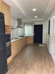 Modern kitchen with wooden flooring and white cabinets