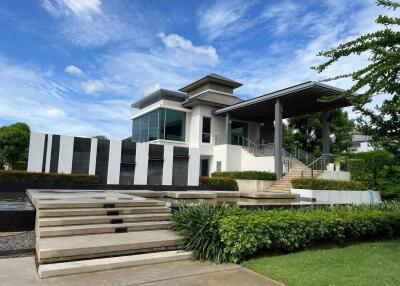 Modern two-story house with large windows and well-maintained garden