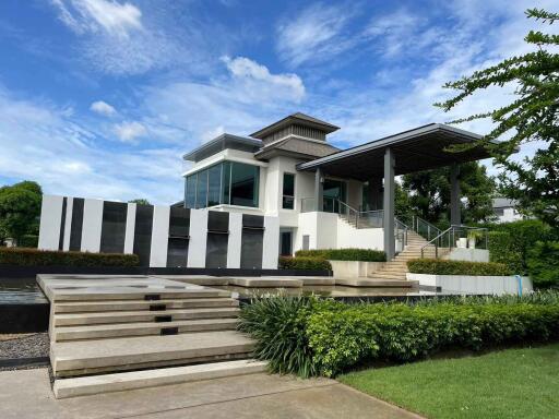 Modern two-story house with large windows and well-maintained garden