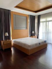 Well-lit bedroom with wooden furniture and large windows