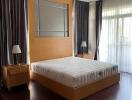 Well-lit bedroom with wooden furniture and large windows