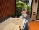 Outdoor area with jacuzzi and covered patio