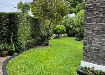 Well-maintained garden with lush greenery and a stone-featured building exterior