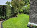 Well-maintained garden with lush greenery and a stone-featured building exterior