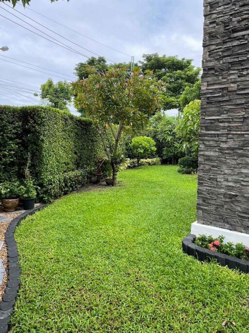 Well-maintained garden with lush greenery and a stone-featured building exterior