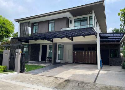 Modern two-story house with carport and fenced yard