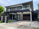 Modern two-story house with carport and fenced yard