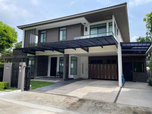 Modern two-story house with carport and fenced yard