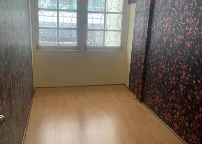 Bedroom with floral wallpaper and wooden floor