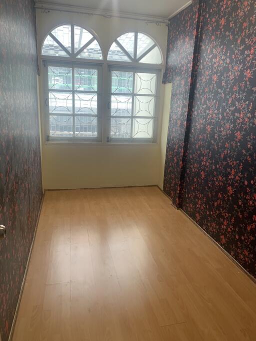 Bedroom with floral wallpaper and wooden floor