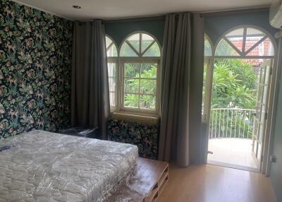 Bright bedroom with floral wallpaper and balcony access