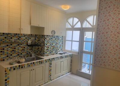 Bright kitchen with tiled backsplash and arched windowed door