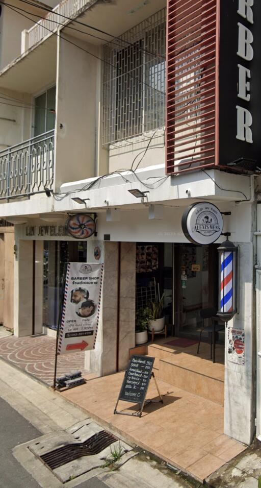 Street view of a commercial building with a barber shop