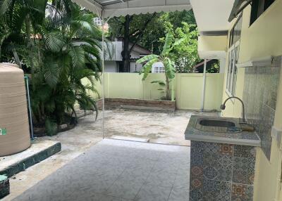 Outdoor patio area with a sink and tiled floor