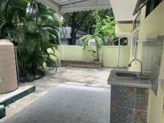 Outdoor patio area with a sink and tiled floor