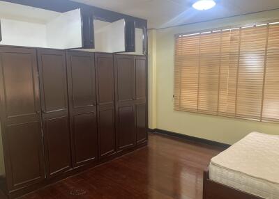 Bedroom with wooden wardrobe and large window