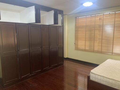 Bedroom with wooden wardrobe and large window