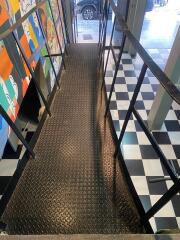 Entrance with metal ramp and checkered floor