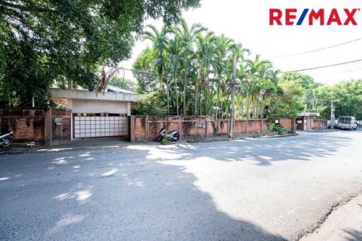 Street view of property entrance with trees and gate