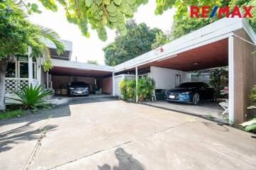 Spacious garage with two cars parked and surrounding greenery