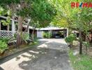 Driveway and garage with lush greenery