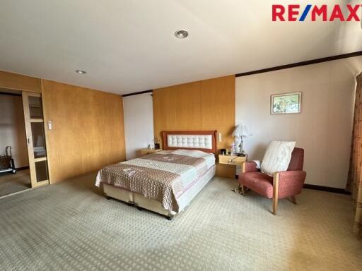 Spacious and cozy bedroom with a double bed and a seating area
