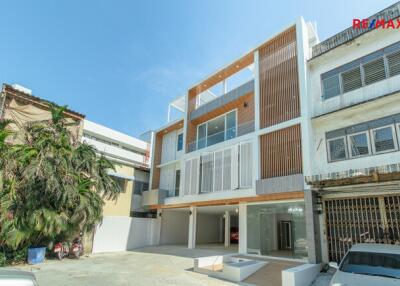 Modern three-story residential building exterior with a driveway