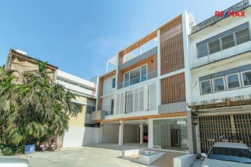 Modern three-story residential building exterior with a driveway